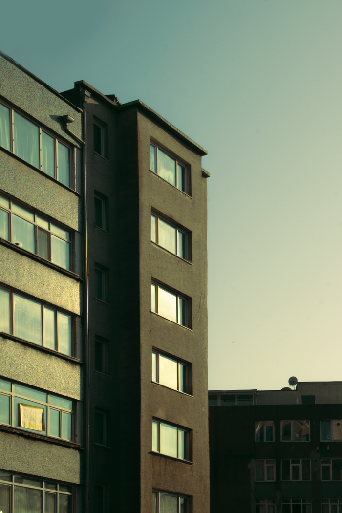 services-02 Vertical shot of a city apartment building exterior during sunset.