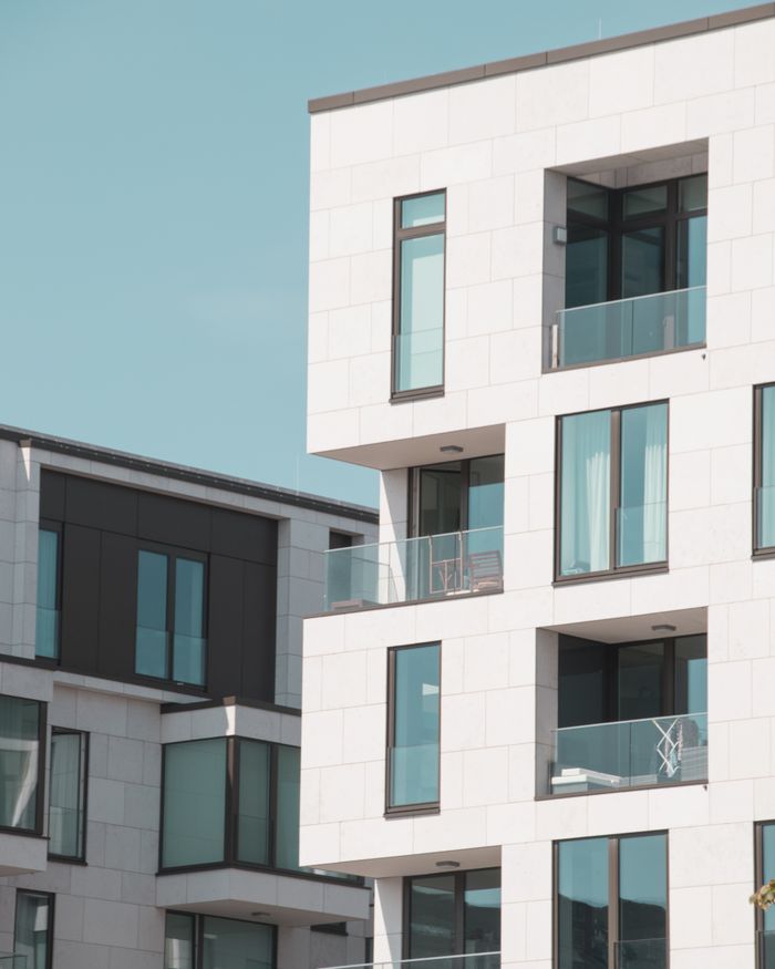 story-img Contemporary apartment buildings in Berlin with elegant white facades and glass balconies.